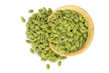 Beyaz arka planda izole edilmiş ahşap kasedeki kabak tohumları. Üst Manzara. Düz yatıyordu.