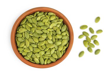 Beyaz arka planda izole edilmiş seramik kasede kabak tohumları. Üst Manzara. Düz yatıyordu.