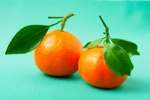 Dos mandarina fresca sobre un fondo verde — Foto de Stock