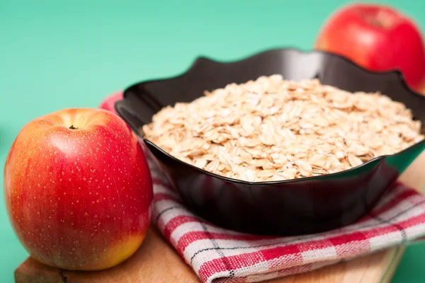 Apple  with oat flakes in bowl — Stock Photo, Image