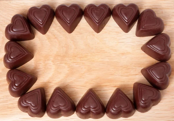 Πλαίσιο από σοκολάτες καρδιά σε ξύλινο φόντο — Φωτογραφία Αρχείου
