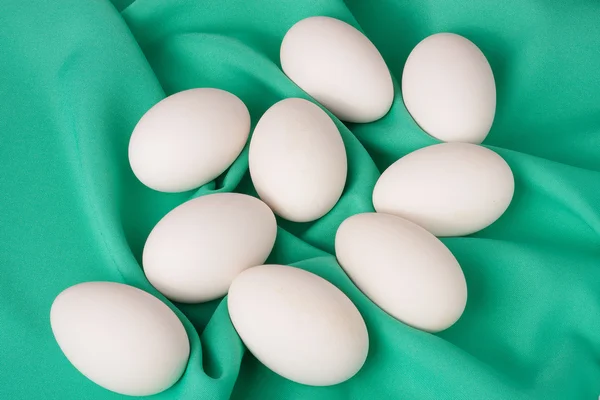 グリーンの布背景に鶏を卵します。 — ストック写真