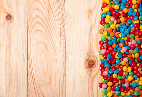 Marco de caramelos de colores sobre fondo de madera — Foto de Stock