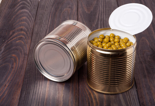 canned green peas in a bank on wooden table
