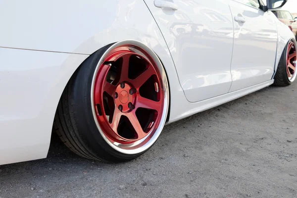Tuned vit bil med extremt låg fjädring och röda hjul. — Stockfoto