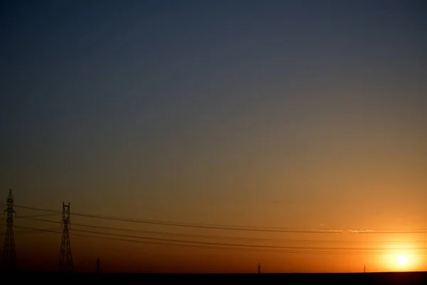 Zonsopgang Met Hoogspanningsleidingen Een Meestal Heldere Hemel — Stockfoto