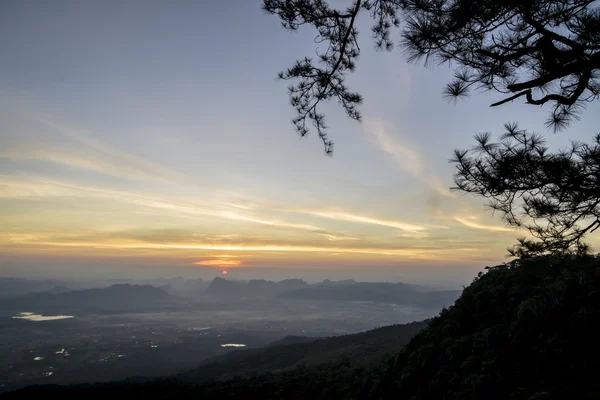 Morgensonnenaufgang mit Nebel am pha nok ann (Schwalbenfelsen) im Phu kradueng Nationalpark, Thailand. Silhouettenlandschaft. — Stockfoto