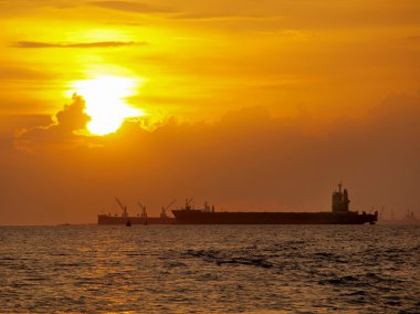 Gün batımında toplu-taşıyıcı gemisiyle denize