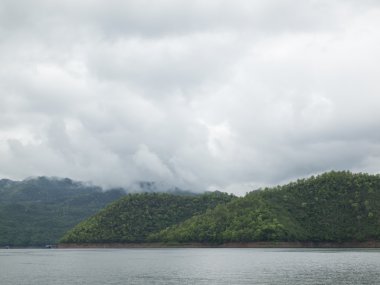 Yatay, dağlar, ağaçlar ve bir göl ön