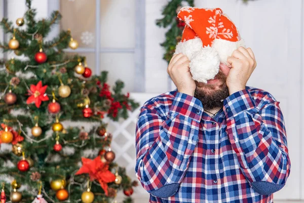 Noel 'de kapalı bir ortamda sakallı adamın yüzünü saklayan elleri ile utangaç bir duygu..