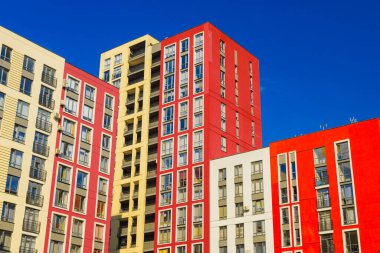modern apartman mimarisi kompleksi açık hava saatinde kırmızı beyaz ve sarı cephe duvarı ve mavi gökyüzü arkaplan geliştirme kavramı