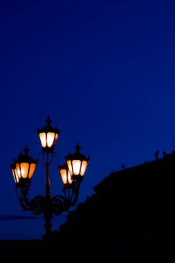 Gece feneri aydınlatma dikey duvar kağıdı fotoğraf konsepti koyu mavi gökyüzü boş kopya alanı ve siyah bina şekli