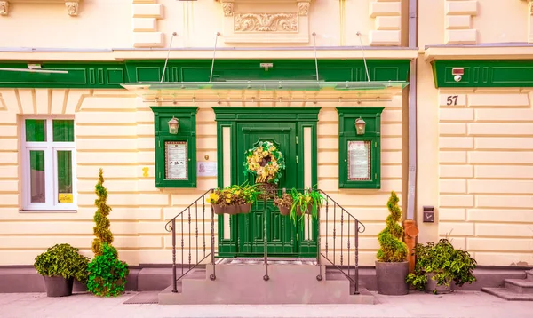 estate exterior vintage house estate in old school style green door and windows shutters and frames and beige wall idyllic background architecture concept