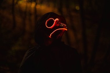 Veba doktoru Steampunk Cadılar Bayramı temalı korkunç karanlık ormandaki Cadılar Bayramı temasının kostümlü portresi cehennem gibi turuncu arka plan ışıklandırması, yumuşak odak ve gürültü kirliliği konsepti gece fotoğrafçılığı