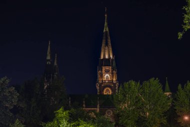 Kilise gecesinin yüksek kulesi, karanlık gökyüzü ve arka planının habercisi.