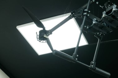 conflict war technology Ukraine drone heavy bomber carbon chassis wing and propellers elements of frame in work shop production studio narrow focus concept under electric lamp light glare