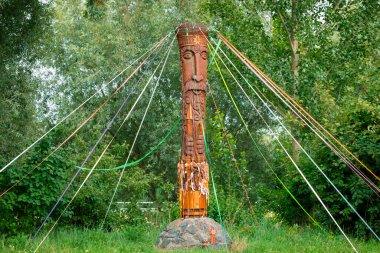 Putperest putperest heykeli, eski köle dininin ahşap sembolüne oyulmuş orman kenarı kırsal kesim ilkbahar çevresindeki şenlikli şeritlerle oyulmuş.