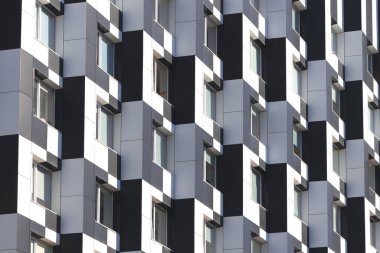 Modern mimari cephesi ofis binası tek renkli siyah beyaz paneller kare şekilli geometrik desenli pencereler arka plan kentsel
