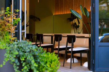 Sabah kahvaltısı için kafe tezgahı sessiz rahat atmosfer. Rutin hafif iç mekan dekorasyonları. Mobilyaların etrafına elektrik lambaları ve bitkiler.