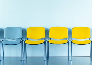 Sandalyeler, boş kopya alanı ve duvar pürüzsüz arkaplanı olan beyaz stüdyo dairesindeki oturma mobilyaları.