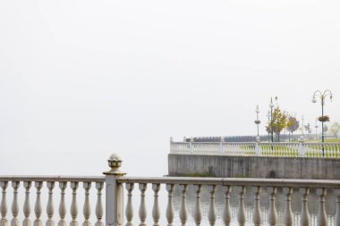 Şehir kıyısı atmosferik mimarisi kıyı şeridi beton yürüme alanı minimalizm stili park meydanı sabah sisli hava zamanı gri hava arka planı fotokopi alanı olan
