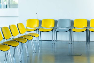 Mülakat salonu lobisi. Müşteriler için sıra sıra sandalye olan iç mekan. İnsanlar artık boş.