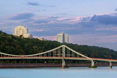 Başkent Kyiv Ukrayna kıyısı nehir kenarı Panorama köprüsü kenti tepesi ve sabah güneşinin alacakaranlıkta doğduğu yer manzarası.