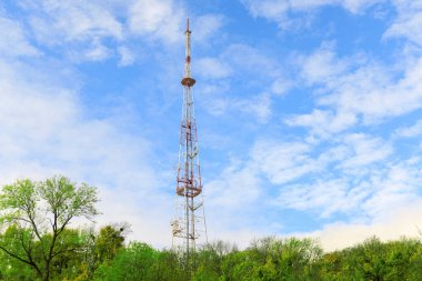 Çimenli yeşil ağaçların arasında tek bir şanzıman kulesi var. Yapısı geniş gökyüzüne karşı bir metal kafes.