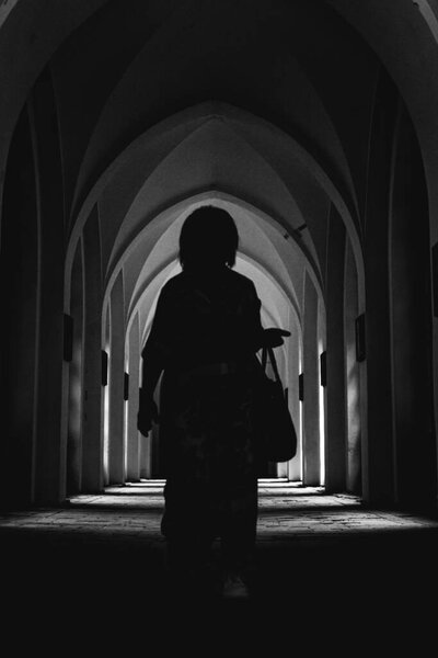 силуэт женщины в коридоре замка, черно-белая фотография