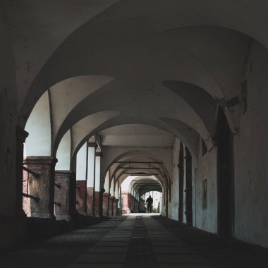 Küçük bir kasabada atari salonu geçidi, arkadan görülen yürüyen bir adam.