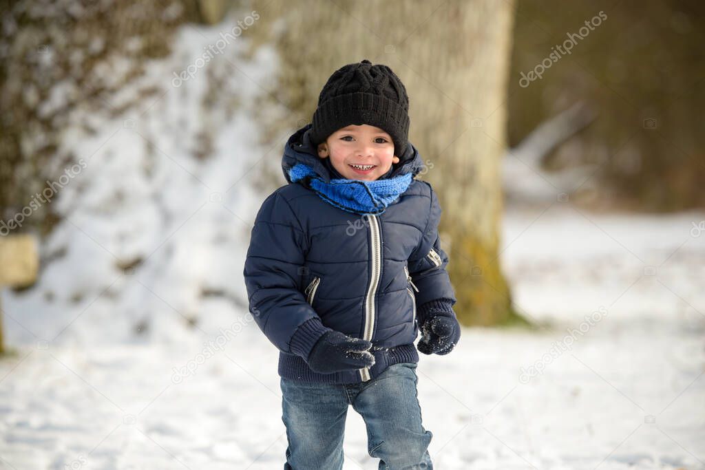 young boy playing under the snow