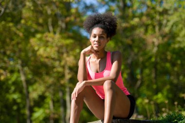 Genç bir kadın parkta koşuyor.