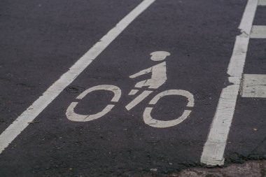 Asfalt yolda boyanmış bisiklet yolu işaretleri, özel bisiklet alanı ve kentsel ulaşım altyapısını gösteriyor.