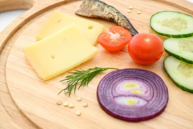 Peynir ve sebzeler doğrama tahtasında. Soğan, salatalık, vişneli domates ve baharat karışımı..