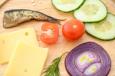 Peynir ve sebzeler doğrama tahtasında. Soğan, salatalık, vişneli domates ve baharat karışımı..