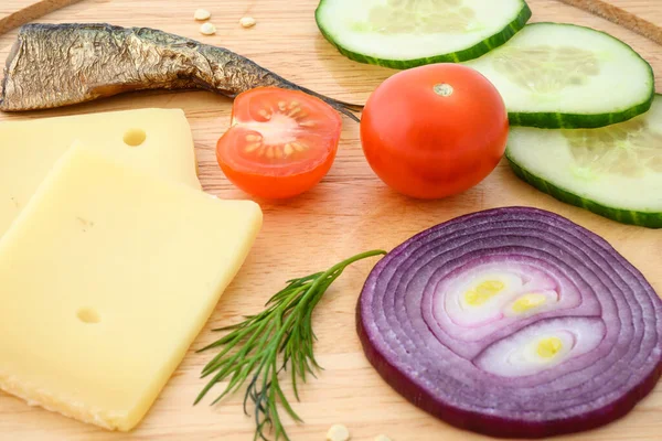 Peynir ve sebzeler doğrama tahtasında. Soğan, salatalık, vişneli domates ve baharat karışımı..