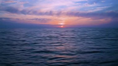 Rusya 'da Karadeniz' de gün batımı. Bulutlar batan güneşin parlak altın ışıklarıyla aydınlanıyor. Deniz manzarası.