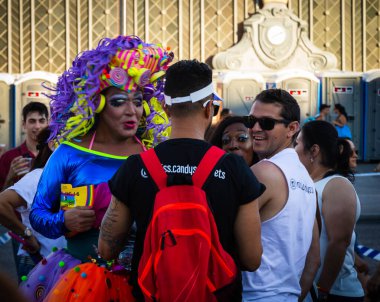 Eğlenen ve gökkuşağı bayrakları dalgalanan insanlar yaz gay onur yürüyüşünde