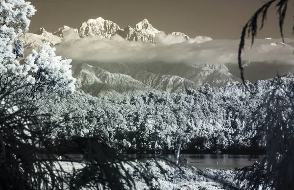 Mountains shrouded in clouds over Okarito Lagoon, New Zealand. Infrared