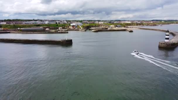 Disparo aéreo de dron invirtiendo hacia arriba sobre el puerto de Seaham y el faro — Vídeo de stock