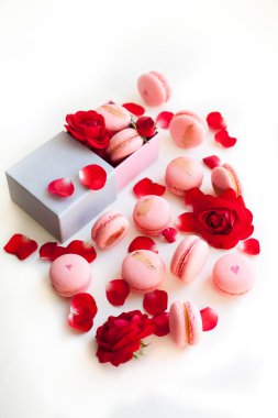 Pink macaron in a gift box with rose petals