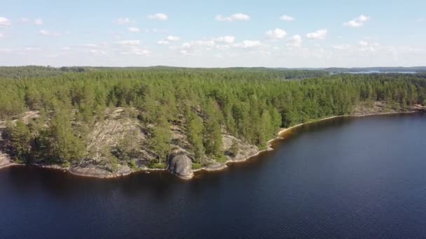 Flygfoto över en klippa vid sjön i Saimen, Finland. Drönaren rör sig i sidled. Vacker sommardag. — Stockvideo