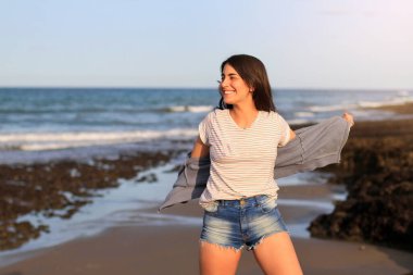 Mutlu kız plajda ceketini çıkarıyor, yaz güneşi, seçici odaklanma.