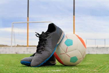 soccer boots supported by the ball with a view to the goal