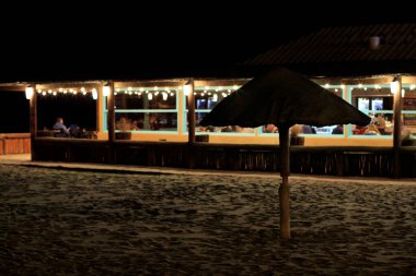 Sahildeki bir restoranın önünde şemsiye.