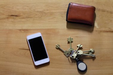 Masanın üzerinde cep telefonu, anahtar ve cüzdan var.