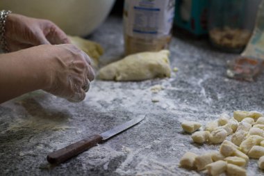 Kadının elleri gnocchi hazırlıyor.