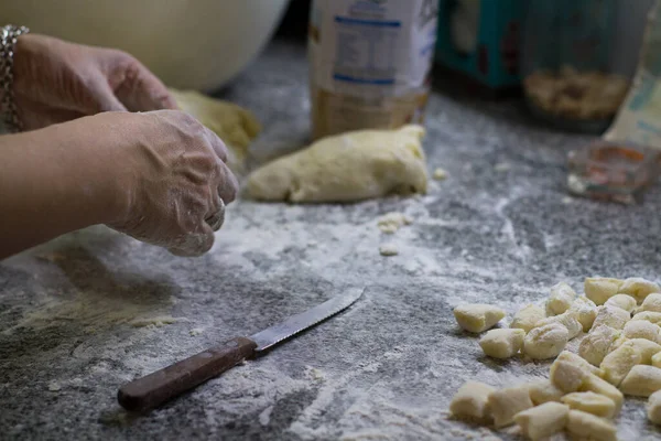Kadının elleri gnocchi hazırlıyor.