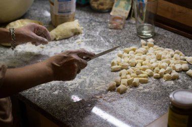 Gnocchi hamuru kesmek için bıçakla hareket eden eller.