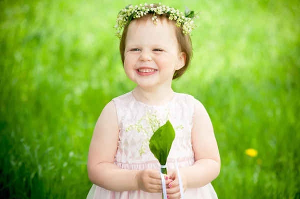 Γλυκό κοριτσάκι στο στεφάνι από λουλούδια χαμογελώντας σε εξωτερικούς χώρους — Φωτογραφία Αρχείου